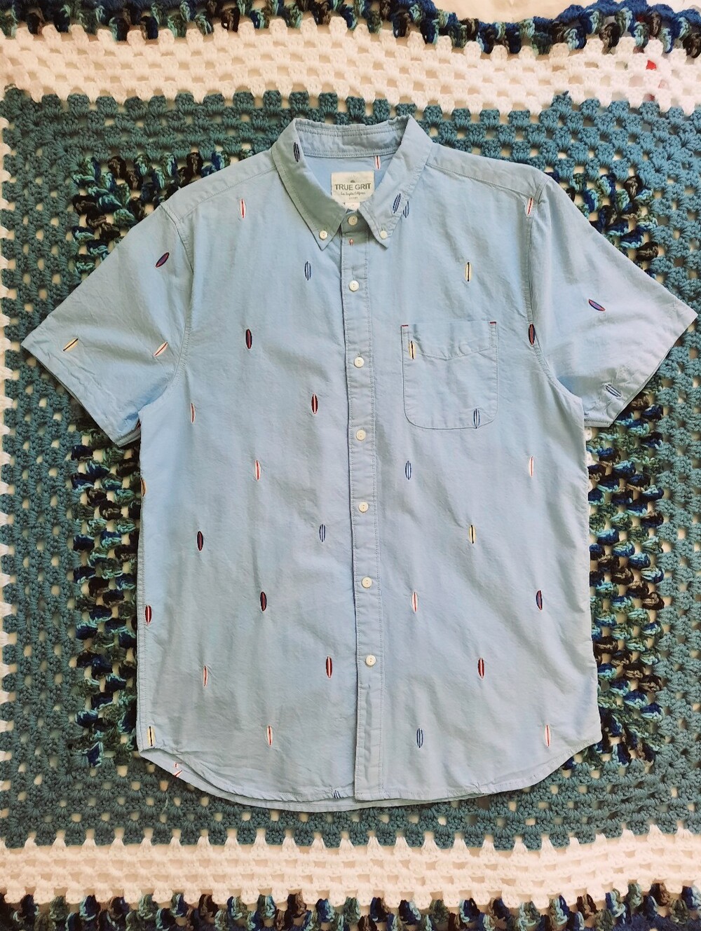 TRUE GRIT Surfboards on Light Blue Short Sleeve Collared Shirt. Pocket